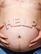 Man's stomach with a sticking out inscription help