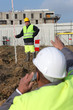 Two men measuring construction site