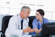 Photo: Serious medical team working with a computer Serious medical team working with a computer