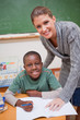 Portrait of a teacher explaining something to a smiling schoolbo