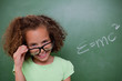 Smart schoolgirl looking above her glasses