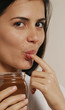 Joven mujer comiendo crema de chocolate. Joven mujer comiendo crema de chocolate.