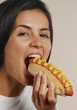 Joven mujer comiendo perro caliente.