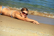 Cropped image of young woman sunbathing at beach