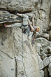 Rock climber clinging to a steep cliff.