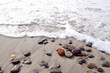 Sea waves beat stones lying in sand on coast line. Sea waves beat stones lying in sand on coast line.