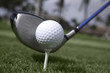 Close up of golf ball on tee and driver set up Close up of golf ball on tee and driver set up