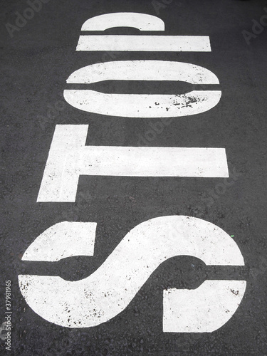 Photo: stop sign painted on a asphalt road surface stop sign painted on a asphalt road surface