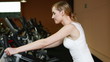 Happy woman using hometrainer in gym