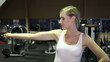 Woman in fitness center using dumbbells
