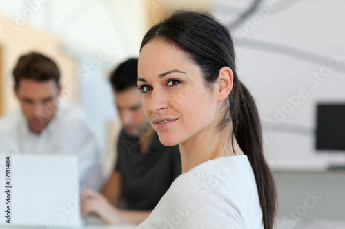 Photo: Jeune femme souriante en réunion de travail Jeune femme souriante en réunion de travail