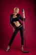 Beauty singer in black leather on red with mic