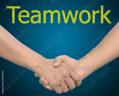Photo: hand in Hand or handshake with the word Teamwork hand in Hand or handshake with the word Teamwork