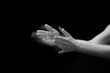 Female hands clapping on black, side-view