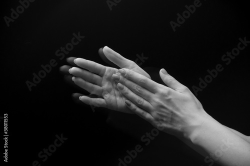 Photo: Female hands clapping on black, side-view Female hands clapping on black, side-view