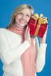 Smiling blond woman with gift box, over blue background