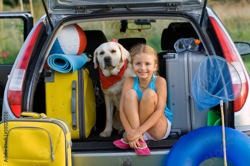 Photo: Girl with dog ready for travel for summer vacation Girl with dog ready for travel for summer vacation