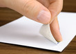 Briefmarke wird auf ein Kuvert geklebt