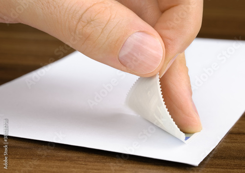 Foto: Briefmarke wird auf ein Kuvert geklebt Briefmarke wird auf ein Kuvert geklebt