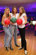 Foto: three girls with balls stand in bowling club three girls with balls stand in bowling club