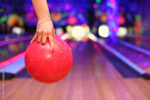 Photo: Female hand holding ball before throwing in bowling club Female hand holding ball before throwing in bowling club