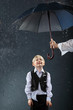 Foto: smiling boy dressed in white shirt standing under umbrella smiling boy dressed in white shirt standing under umbrella