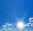 Clouds and sun rays in the blue sky