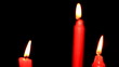 Three red candles on black background