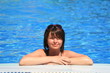 Young woman leaning on the edge of a pool