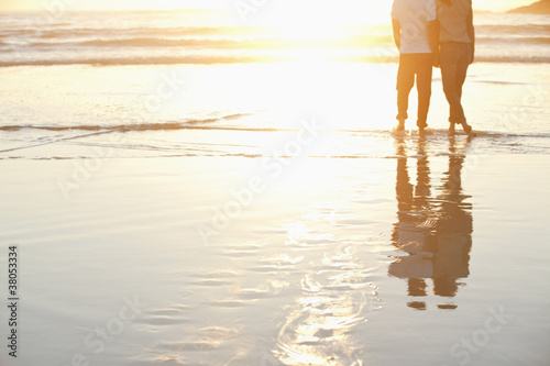 Foto: Couple watching sunset on beach Couple watching sunset on beach