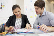 Businessman and businesswoman reviewing paperwork in office