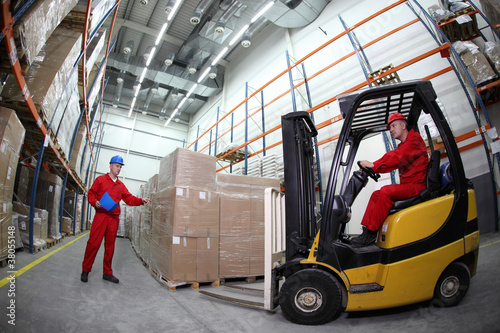 Photo: two workers loading pallets with forklift truck two workers loading pallets with forklift truck