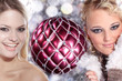 Zwei hübsche Frauen mit Weihnachts Kugel
