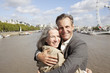 Portrait of smiling couple hugging in front of Thames river