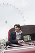 Happy man riding double decker bus in London