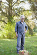Portrait of smiling senior man wearing coveralls in apple orchard