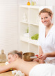junge frau verabreicht eine klangschalentherapie