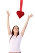 Photo: Woman in love trying to reach red heart smiling Woman in love trying to reach red heart smiling