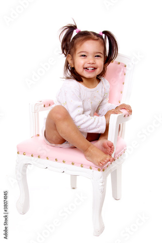 Photo: petite fille souriante sur une chaise ancienne couleur rose petite fille souriante sur une chaise ancienne couleur rose