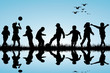 Silhouettes of children playing near a water