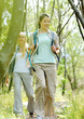 Two young women hiking between the trees