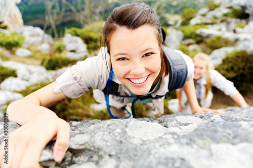 Photo: Hiker smiles while climbing up a rocky wall Hiker smiles while climbing up a rocky wall