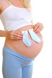 The pregnant woman holds small socks