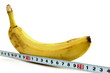 Large banana and measuring tape on white background