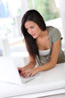 Photo : Beautiful young woman working at home on laptop computer