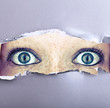 Foto: Augen starren durch Papierloch Augen starren durch Papierloch