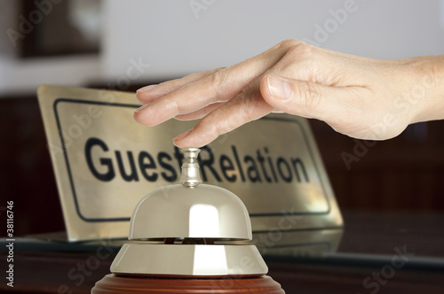Photo: Hand of a woman using a hotel bell Hand of a woman using a hotel bell
