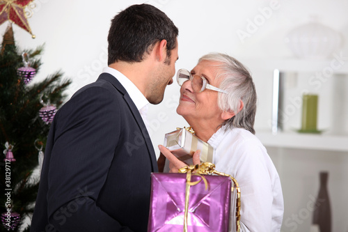 Photo: Son giving mother Christmas present Son giving mother Christmas present