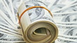 Rotating rolled up bundle of 100 dollar notes on money Rotating rolled up bundle of 100 dollar notes on money