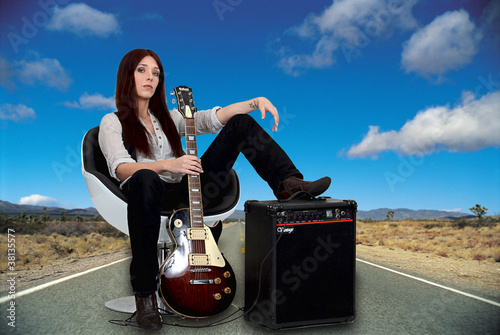 Photo: Stylized female guitarist with her amp on the road Stylized female guitarist with her amp on the road
